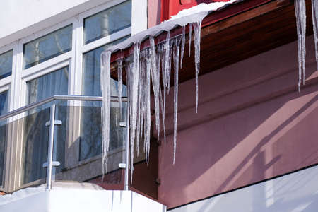 Long transparent icicles on the roof on a spring sunny day.の写真素材