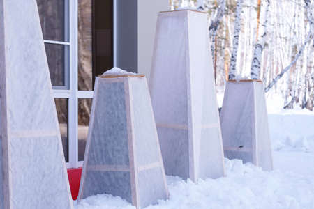 Protection of trees for the winter from wind, sun and frost. Wooden box for plants.