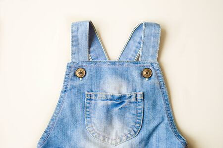 Straps from a denim jumpsuit on a white background.