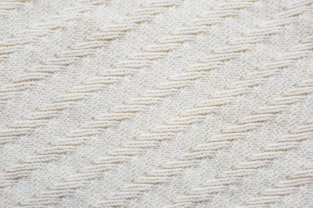 The texture of the fabric. White knitted pattern. background.