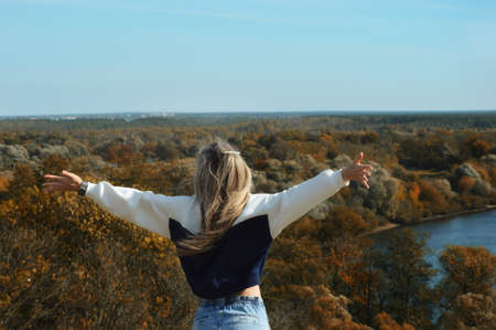 Selfportrait. Girl in the Park. Nature autumn, river, trees and sky. Beautiful blue horizon.