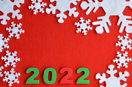 white snowflakes made of felt on a red background. Registration for the New Year. number 2022の写真素材