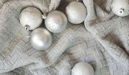 gray shiny Christmas balls on a knitted plaid. background for Christmas and New Year. winter...