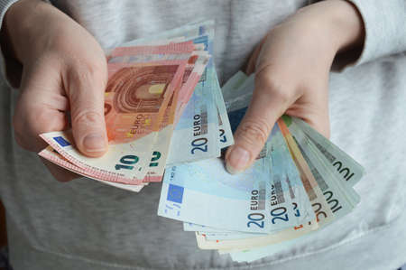 Moscow, Russia, 03/27/2022, a woman counts banknotes with her hands. European money, euro.の写真素材
