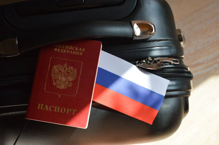 the flag of the Russian Federation and the passport of a Russian citizen on a black suitcase for travel. background for the design.の写真素材