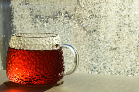 a mug of tea on the background of a sunny window. bokeh. the light of the sun. hot drink.の写真素材
