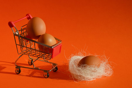 Eggs in a shopping cart on a bright orange background.の写真素材