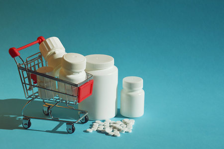 Shopping cart with pills on blue background with copy space for text