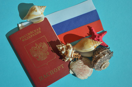 Russian passport and flag, symbol of the state. seashells on a blue background. departure for citizens of the Russian Federationの写真素材