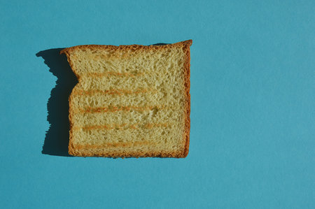 Slice of bread on blue background. top view. copyspace.