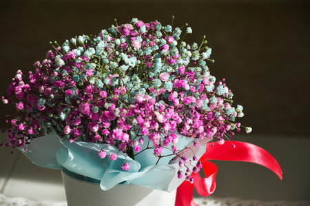 Bouquet of artificial flowers in a vase on the tableの写真素材