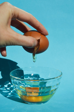 Eggs in a glass bowl with water on a blue background