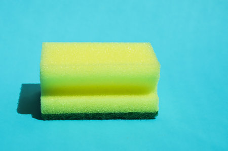 Sponge for washing dishes on a blue background. close-up.の写真素材