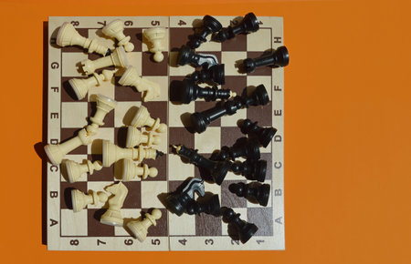 Chess board with chess pieces on orange background. top view.