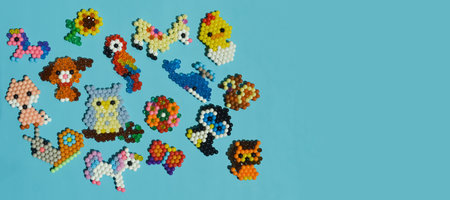 Colorful plastic beads of different shapes and sizes on a blue background