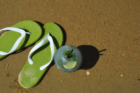 Flip flops and candle on the sand of the beach.の写真素材