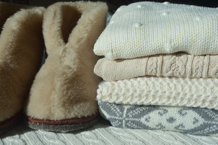 Pile of winter clothes. Knitted woolen sweaters and mittens