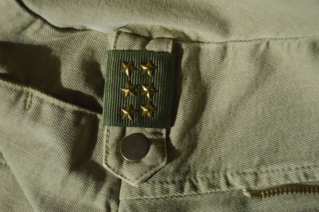 Green military uniform with gold stars on it. Close-up.