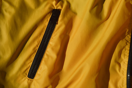 Yellow raincoat with zipper. Close-up of a raincoat.