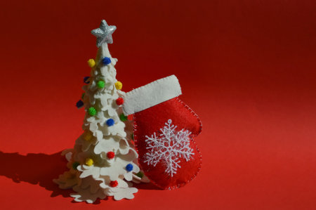 Christmas decoration on red background. Christmas tree made of felt and toysの写真素材
