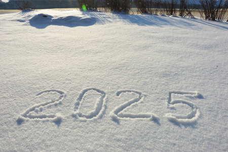 Happy New Year 2015 written on fresh snow with blue sky background.