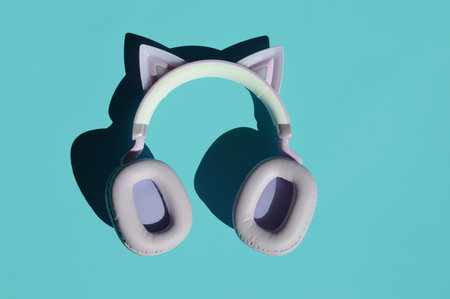 White headphones on a turquoise background. Minimal concept.