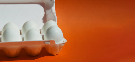 Eggs in a white box on a red background with copy spaceの写真素材