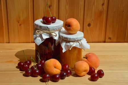 Homemade apricot jam with fresh fruits on wooden table.の写真素材