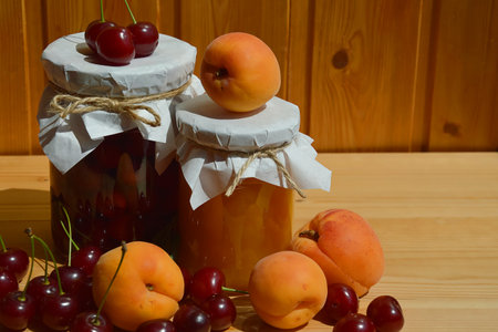 Homemade apricot jam with fresh fruits on a wooden tableの写真素材