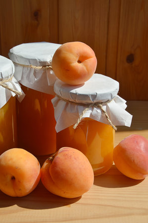Apricot jam in a glass jar and fresh apricotsの写真素材