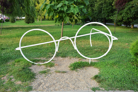 Pair of white round glasses on the green grass in the park