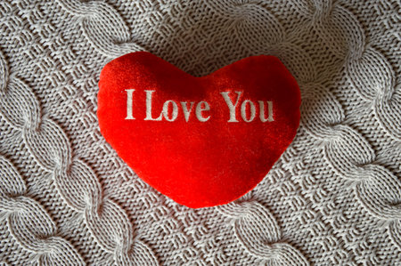 Valentine's day background with red heart on knitted background