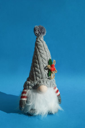 Knitted gnome on a blue background. Christmas greeting card.の写真素材
