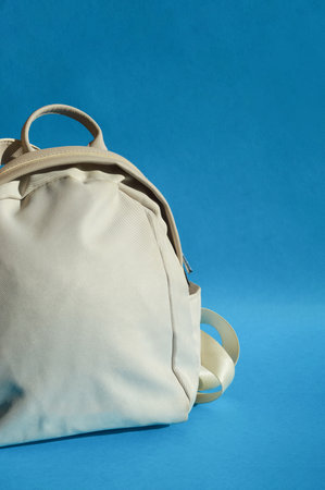 White leather backpack on a blue background. Back view. Copy spaceの写真素材