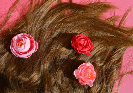 Hair with flowers on pink background. Top view. Flat lay.の写真素材