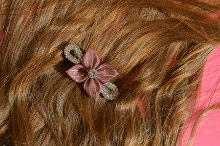 wavy hair with a bow on a pink background close-upの写真素材