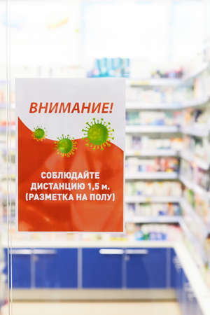 Nizhniy Novgorod - 2020: Announcement about safety requirements due to coronavirus outbreak with warning text banner sign in Russian at the entrance to the pharmacy, The coronavirus pandemic of COVID-19 in Russia. "Please keep distance".のeditorial素材