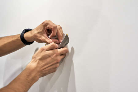 Close up of Electrician worker during work of installing new lamp in the house during repairs. Wire...