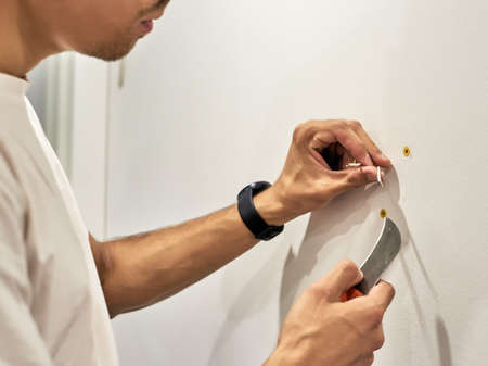 Close up of Electrician worker during work of installing new lamp in the house during repairs. Wire preparation by stripping cables.の写真素材
