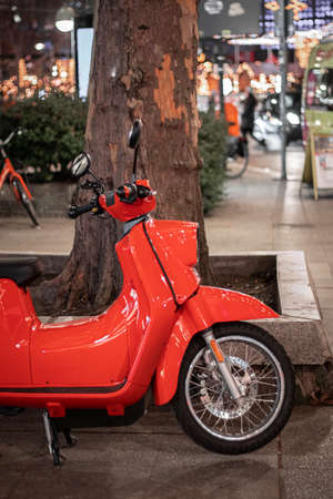 Berlin / Germany - 01 05 2020: Bright Red Scooter parked In An Urban Street on a sidewalk under the...