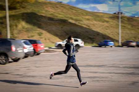 Motion blured, Young woman running outdoors in the courtyard