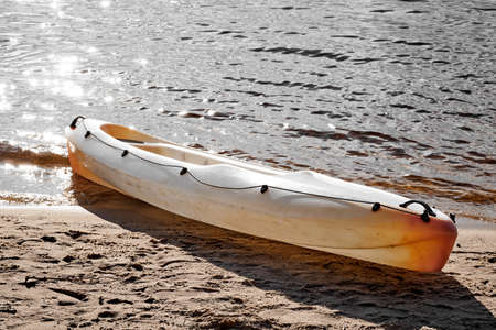 Orange Kayak on the shore in sunlight