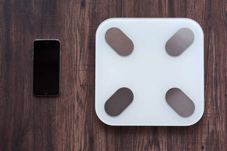 Top View Of a Smart Weighing Scale and a smartphone connected to the Weighing Scale with copy space. Smart technology conceptの写真素材
