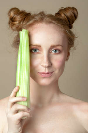 Face of a beautiful girl with radiant skin and celeryの写真素材