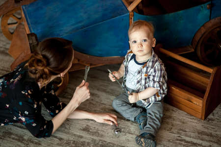 Young boy mechanic repairing the robot in the workshop at night