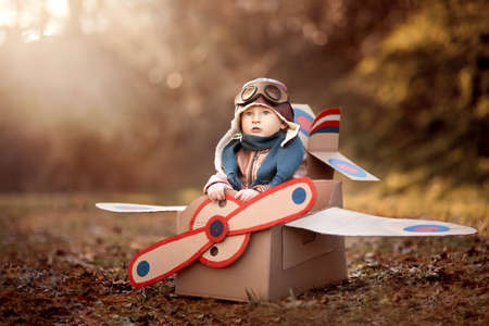 the boy plays in an airplane made of cardboard box and dreams of becoming a pilotの写真素材