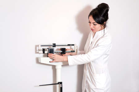 young doctor woman at medical office with hand on the head thinking about question, pensive expression. Doubt concept.の写真素材