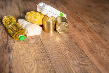 Various uncooked cereals, grains, pasta, oil and canned food on a wooden table. Flat lay.の写真素材