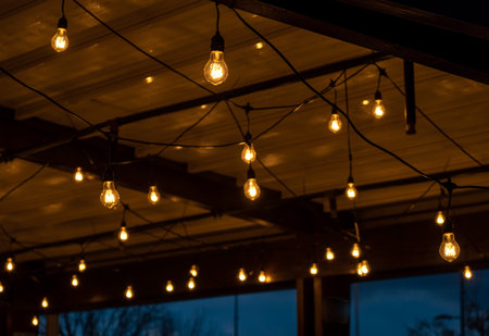 Atmospheric photo of a evening cafe with round light bulbsの写真素材