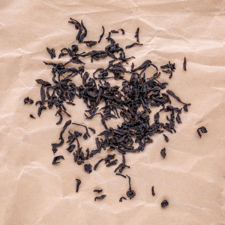 Black selected dry tea scattered on a neutral backgroundの写真素材